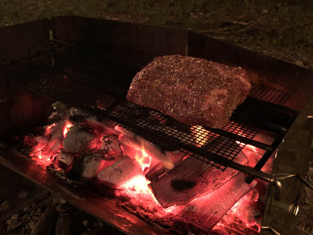 薪グリルで肉塊を焼く